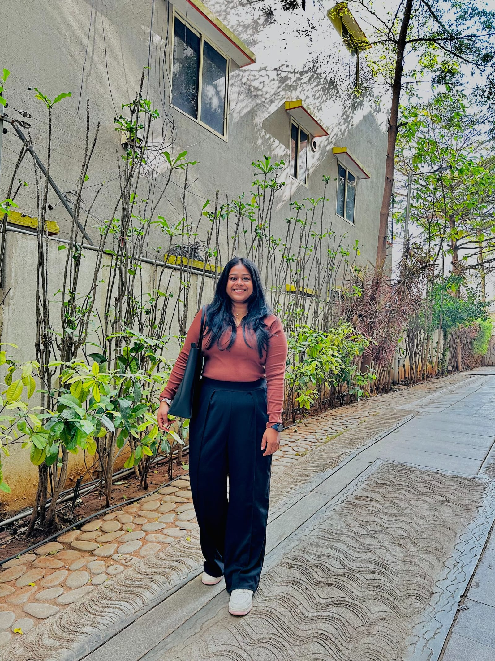 Akhila Nair standing outdoors along a green walkway